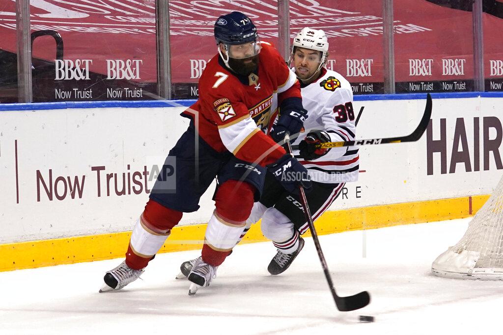 Marta Lavandier Detroit Pistons guard Killian Hayes (7) and Chicago Blackhawks left wing Brandon Hagel (38) go after the puck during the third period of an NHL hockey game Tuesday, Jan. 19, 2021, in Sunrise. (AP Photo/Marta Lavandier)