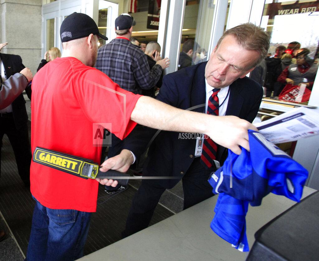 Charles Rex Arbogast FILE - In this May 2, 2011, file photo, a United Center security officer uses a wand as he checks for prohibited items as a fan arrives for Game 1 of a second-round NBA playoff basketball series between the Chicago Bulls and the Atlanta Hawks, in Chicago. The metal detectors that greet sports fans at the gates might soon be accompanied by thermal body scanners, in the gargantuan task of better protecting venues from virus spread in order to bring the games back for in-person viewing. (AP Photo/Charles Rex Arbogast, File)