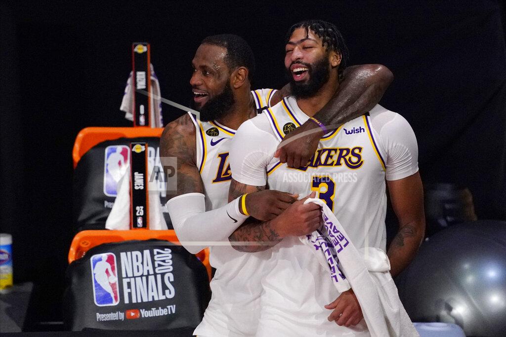 FILE - Los Angeles Lakers' LeBron James, rear, and Anthony Davis (3) celebrate after the Lakers defeated the Miami Heat 106-93 in Game 6 of basketball's NBA Finals in Lake Buena Vista, Fla., in this Oct. 11, 2020, file photo. Anthony Davis is finalizing a five-year contract worth up to $190 million to return to the Los Angeles Lakers. Davis' agent, Rich Paul of Klutch Sports, confirmed the terms of Davis' pending free agent deal to The Associated Press on Thursday, Dec. 3, 2020. One day after LeBron James agreed to a two-year, $85 million contract extension with the Lakers through 2022-23, Davis committed to the Lakers through the 2024-25 season. (AP Photo/Mark J. Terrill, File)
