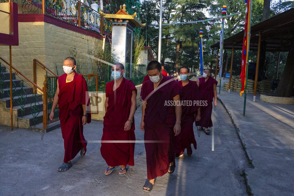 Ashwini Bhatia Exile Tibetan Buddhist monks wear masks as protection against the coronavirus as they circumambulate the residence of Tibetan spiritual leader the Dalai Lama in Dharmsala, India, Sunday, Sept. 27, 2020. (AP Photo/Ashwini Bhatia)