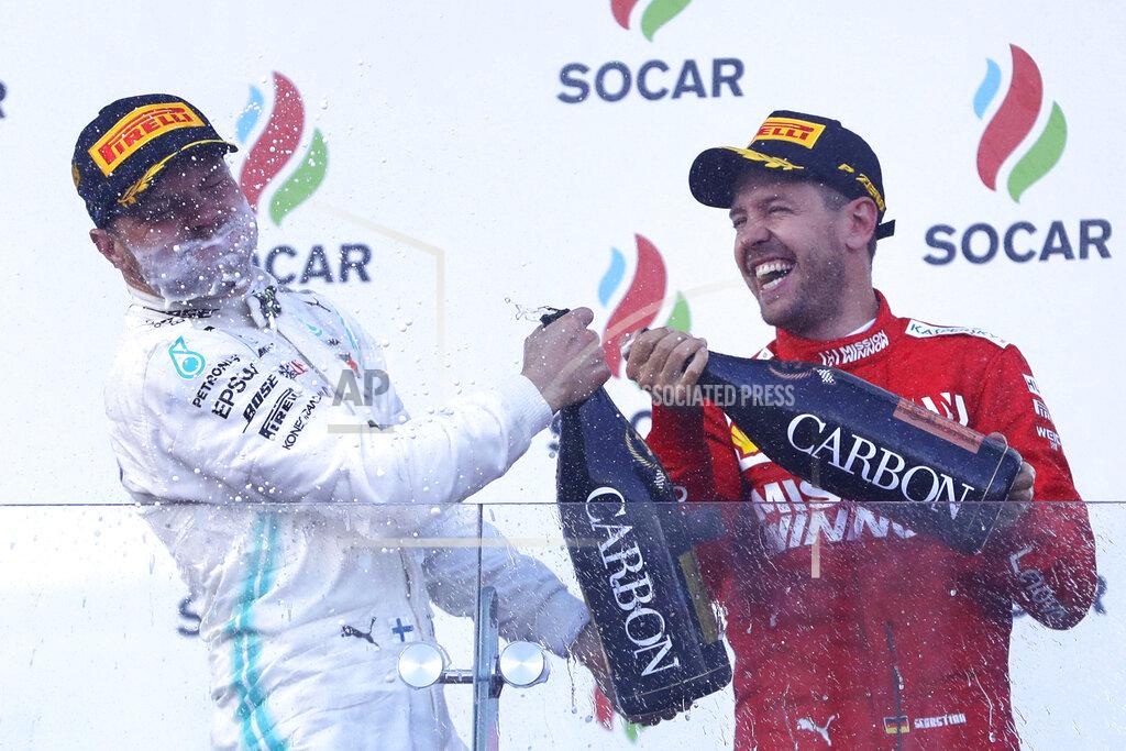 Sergei Grits Mercedes driver Valtteri Bottas of Finland, left, celebrates with third placed Ferrari driver Sebastian Vettel of Germany after winning the Formula One Grand Prix at the Baku Formula One city circuit in Baku, Azerbaijan, Sunday, April 28, 2019. (AP Photo/Sergei Grits)