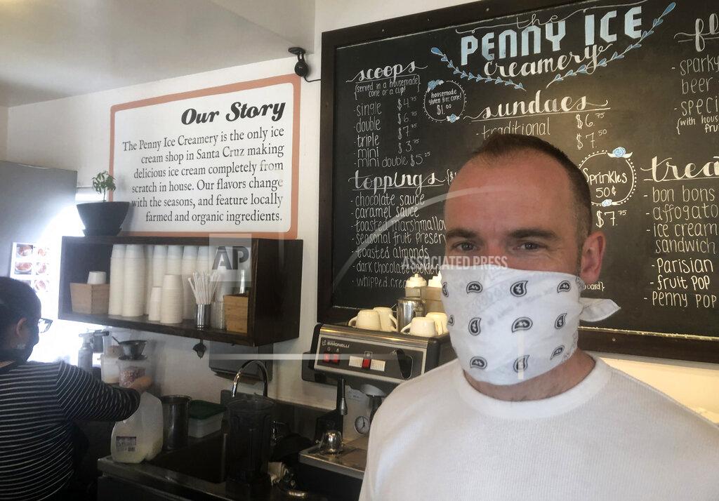 Martha Mendoza Wearing a protective mask, Zachary Davis poses for a photo at The Penny Ice Creamery in Santa Cruz, Calif. Friday, April 17, 2020. Davis, who owns two ice cream parlors, a beachside cafe and a taco bar in Santa Cruz, has had to lay off 70 employees due to the coronavirus outbreak. (AP Photo/Martha Mendoza)