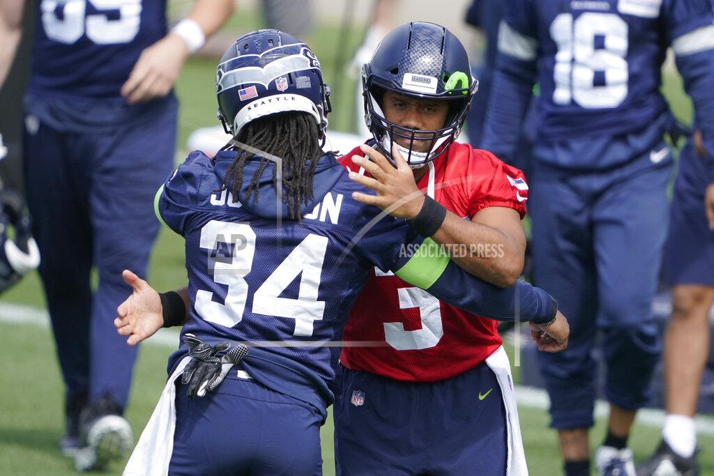 Ted S. Warren Seattle Seahawks quarterback Russell Wilson, right, hugs running back Josh Johnson at the start of NFL football practice Tuesday, June 8, 2021, in Renton, Wash. (AP Photo/Ted S. Warren)