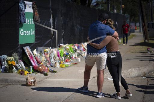 FILE - Two people who knew an unidentified victim of a fatal incident at the Houston Astroworld concert embrace at a memorial on Sunday, Nov. 7, 2021. The family of two close friends from suburban Chicago who were killed at the Astroworld concert in Houston this month have filed wrongful death lawsuits against rapper Travis Scott, the Live Nation entertainment company and others. (AP Photo/Robert Bumsted, File)