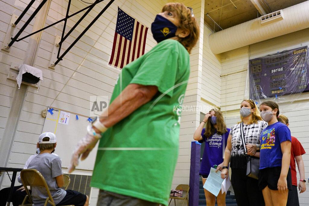 Nam Y. Huh Students and parents wear mask as they wait to receive a second dose of the Pfizer COVID-19 vaccine during a vaccination clinic hosted by Jewel Osco at London Middle School in Wheeling, Ill., Friday, June 11, 2021. After nearly 15 months of shutdowns, limited capacity and sheltering at home, the State of Illinois, including Chicago, fully reopened today. Businesses still can have their own rules for capacity, masks and social distancing. Masks are still required on public transportation and in airports, schools and hospitals. (AP Photo/Nam Y. Huh)