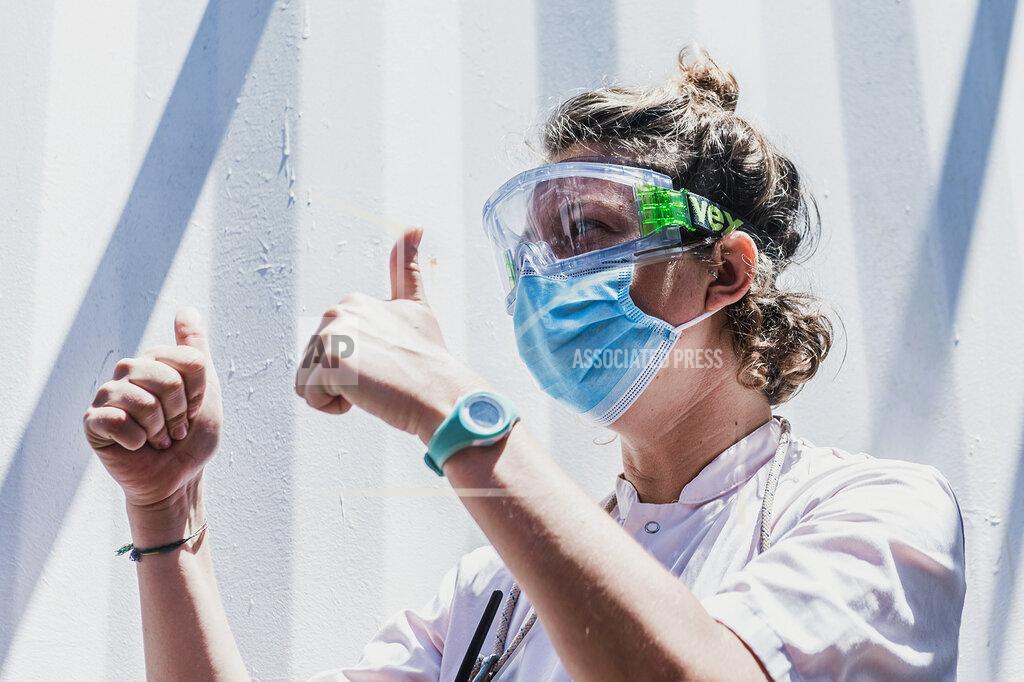 Flavio Gasperini A staffer wearing a mask gives the thumb-up sign aboard the Ocean Viking ship in the Mediterranean Sea, Sunday, July 5, 2020. A humanitarian group says its rescue ship with 180 migrants stranded aboard for days has “finally” received instructions to sail to an Italian port, so its passengers can be disembarked. SOS Mediterranee in a tweet on Sunday also described “relief on the #Ocean Viking” when the ship's crew and passengers learned that the rescued migrants are to be disembarked at Porto Empedocle, Sicily, the next day. (Flavio Gasperini/SOS Mediterranee via AP)