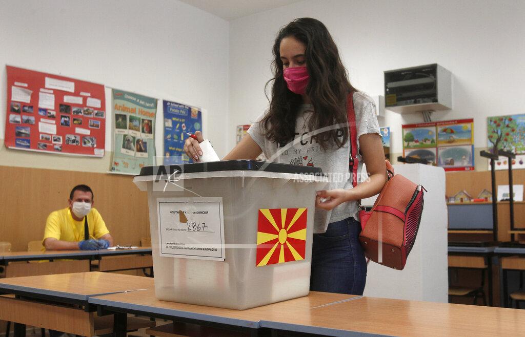 Boris Grdanoski A young woman wearing face mask to protect from coronavirus, casts her ballot in the parliamentary elections in a polling station in Skopje, North Macedonia, Wednesday, July 15, 2020. Voters in North Macedonia headed to the polls on Wednesday in the country's general election despite an alarming spike in coronavirus cases in the tiny Balkan nation. (AP Photo/Boris Grdanoski)
