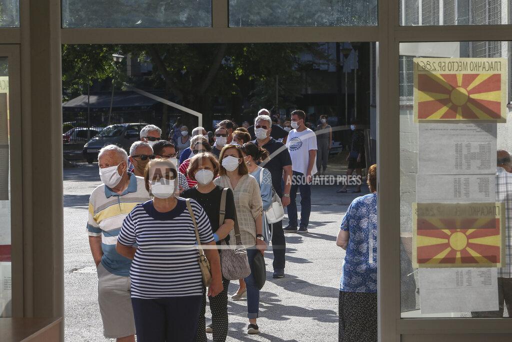 Boris Grdanoski People wearing face masks queue outside a polling station as they wait to vote in Skopje, North Macedonia on Wednesday, July 15, 2020. Voters in North Macedonia were heading to polls early on Wednesday in the country's general election despite an alarming spike in coronavirus cases in the tiny Balkan nation. (AP Photo/Boris Grdanoski)