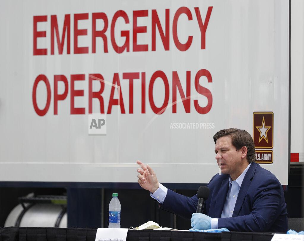Florida Gov. Ron DeSantis, gestures as he speaks during a news conference in front of a U.S. Army Corps of Engineers mobile command center at the Miami Beach Convention Center, Wednesday, April 8, 2020, in Miami Beach, Fla. The Corps of Engineers will transform the newly renovated facility into a hospital by April 27, news outlets reported Tuesday. (AP Photo/Wilfredo Lee)