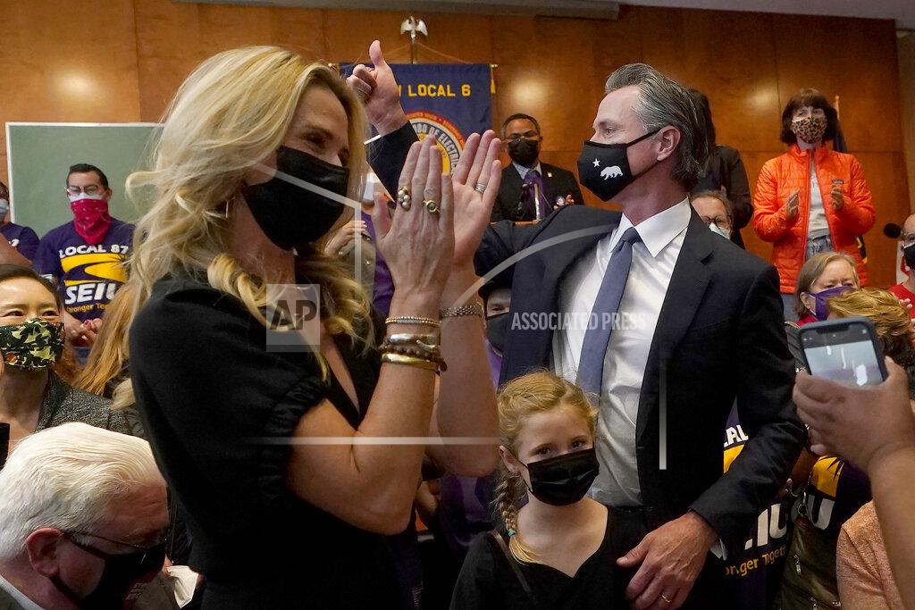 Jeff Chiu Gov. Gavin Newsom, middle right, gestures next to his wife, Jennifer Siebel Newsom, foreground, and their daughter, Brooklynn, bottom, after speaking to volunteers in San Francisco, Tuesday, Sept. 14, 2021. The recall election that could remove California Democratic Gov. Newsom is coming to an end. Voting concludes Tuesday in the rare, late-summer election that has emerged as a national battlefront on issues from COVID-19 restrictions to climate change. (AP Photo/Jeff Chiu)