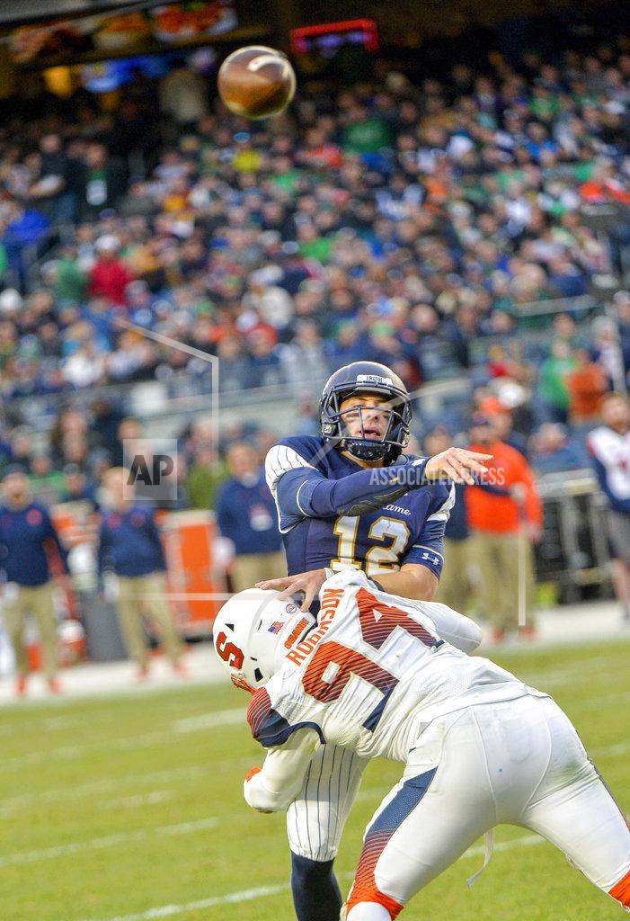 Howard Simmons Notre Dame quarterback Ian Book (12) makes throw under pressure from Syracuse defensive lineman Alton Robinson (94) during the first half of an NCAA college football game, Saturday, Nov. 17, 2018, at Yankee Stadium in New York. (AP Photo/Howard Simmons)