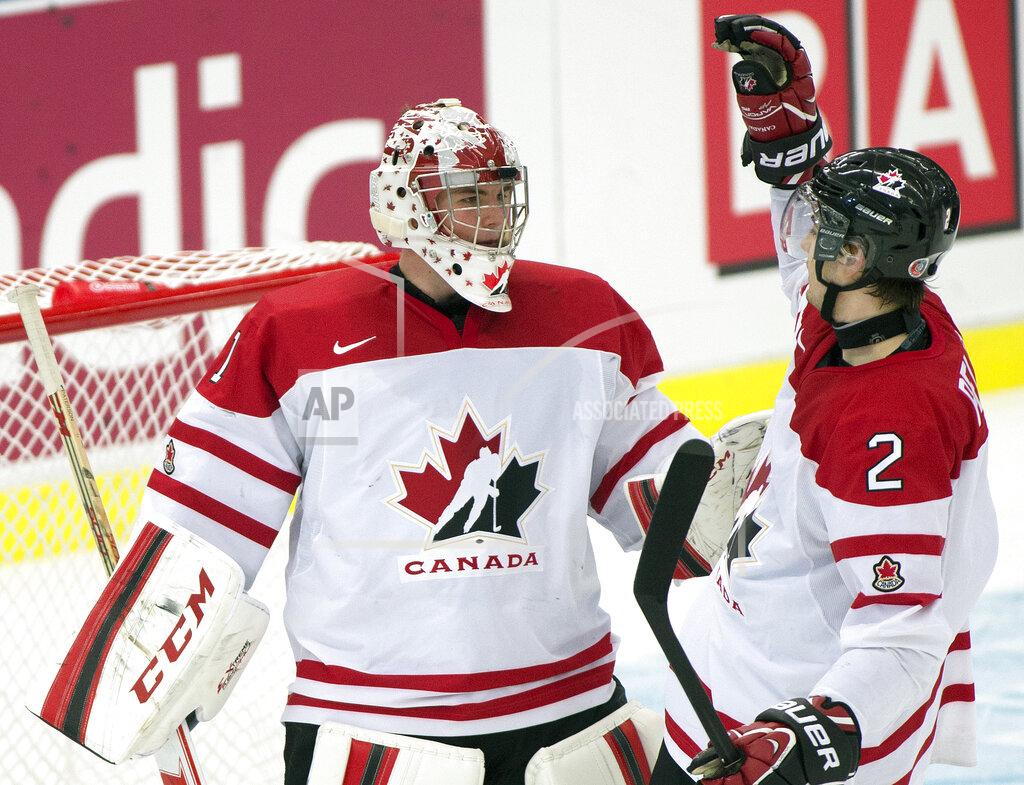Frank Gunn FILE - Team Canada goaltender Jake Paterson is congratulated by defenseman Adam Pelech after defeating Germany in a qualification round game at the IIHF World Junior Hockey Championships in Malmo, Sweden, in this Thursday, Dec. 26, 2013, file photo. Goaltender Jake Paterson is studying to get his real estate license while also playing minor league hockey with the Allen Americans of the ECHL. Paterson joined the Professional Hockey Players Association’s career enhancement program last spring after the COVID-19 pandemic hit. (AP Photo/The Canadian Press, Frank Gunn, FIle)