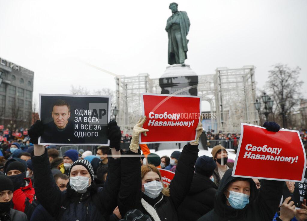 Pavel Golovkin People gather during a protest against the jailing of opposition leader Alexei Navalny in Pushkin square at the statue of Alexander Pushkin in the background in Moscow, Russia, Saturday, Jan. 23, 2021. Protesters hold posters reading "Freedom for Navalny!" and "One for all and all for one" with Navalny's portrait. Russian police on Saturday arrested hundreds of protesters who took to the streets in temperatures as low as minus-50 C (minus-58 F) to demand the release of Alexei Navalny, the country's top opposition figure. Navalny, President Vladimir Putin's most prominent foe, was arrested on Jan. 17 when he returned to Moscow from Germany, where he had spent five months recovering from a severe nerve-agent poisoning that he blames on the Kremlin. (AP Photo/Pavel Golovkin)