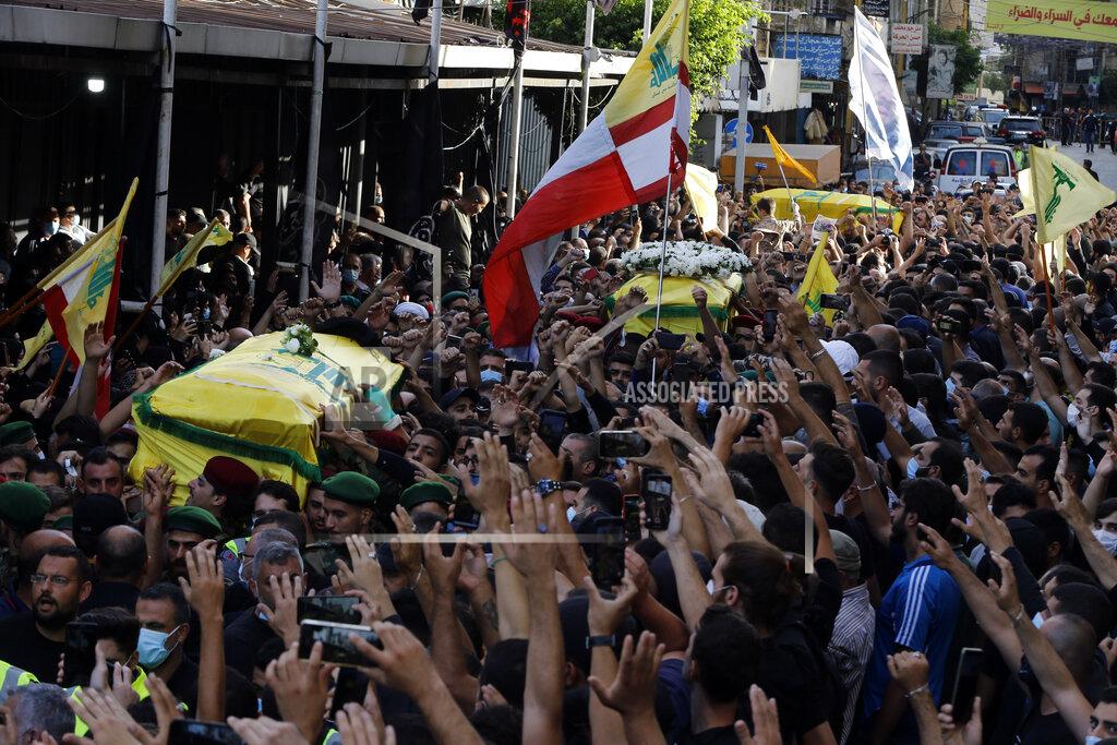 Bilal Hussein FILE - In this Oct. 15, 2021 file photo, mourners carry the coffins of three Hezbollah supporters who were killed during Thursday clashes, during their funeral processions in the southern Beirut suburb of Dahiyeh, Lebanon. The shootout on the streets of Beirut between rival Christian and Muslim groups has revived memories of the country's 1975-90 civil war and fired up sectarian passions in a country that never dealt with the causes of its violent past. (AP Photo/Bilal Hussein, File)