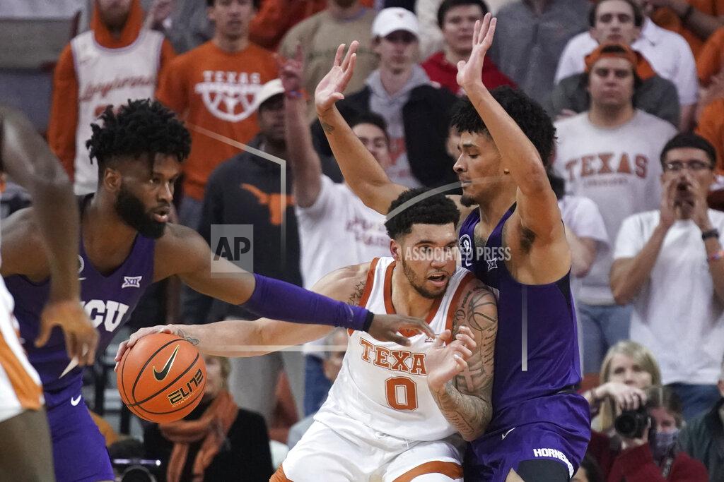Chuck Burton Texas forward Timmy Allen, left, drives against TCU guard Micah Peavy, right, during the first half of an NCAA college basketball game in Austin, Texas, Wednesday, Feb. 23, 2022. (AP Photo/Chuck Burton)