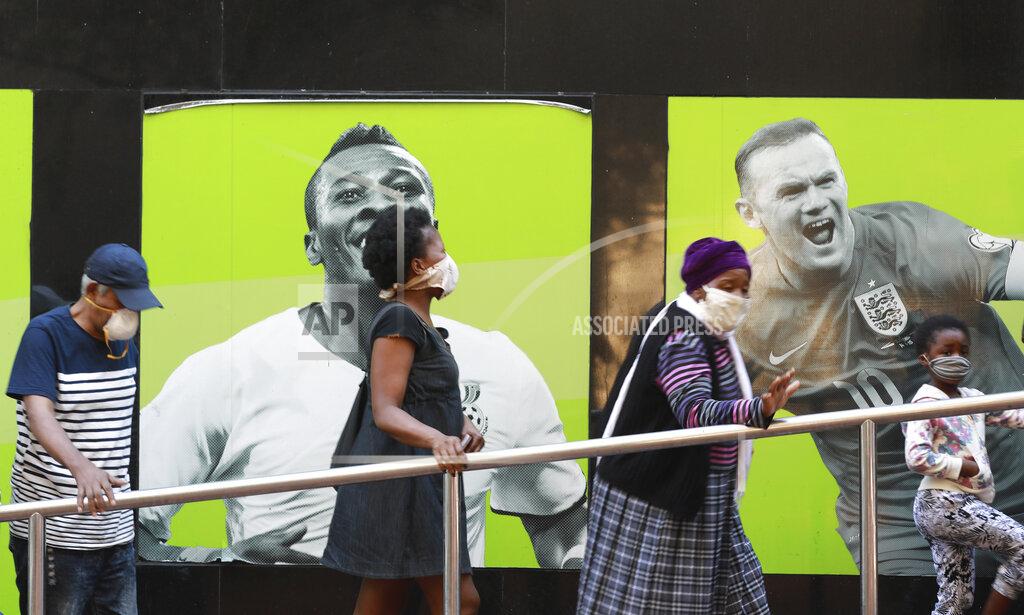 People wearing face masks queue at a South African Social Security Agency (SASSA) to collect their government grant in Cape Town South Africa, Monday, May 11, 2020. South Africa's Western Cape province, which includes the city of Cape Town, has emerged as the country's coronavirus hotspot, accounting for more than half of the nation's confirmed cases, which have gone above 10,000.(AP Photo/Nardus Engelbrecht)