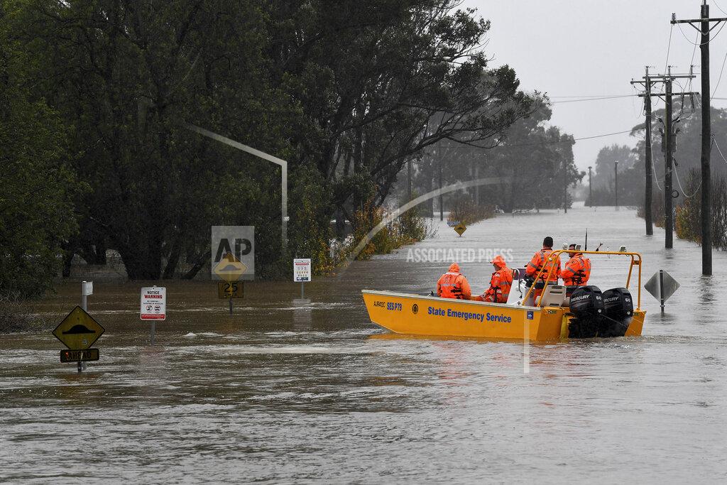 Bianca De Marchi A New South Wales State Emergency Service (SES) crew is seen in a rescue boat as roads are submerged under floodwater from the swollen Hawkesbury River in Windsor, northwest of Sydney, Monday, July 4, 2022. (Bianca De Marchi/AAP Image via AP)