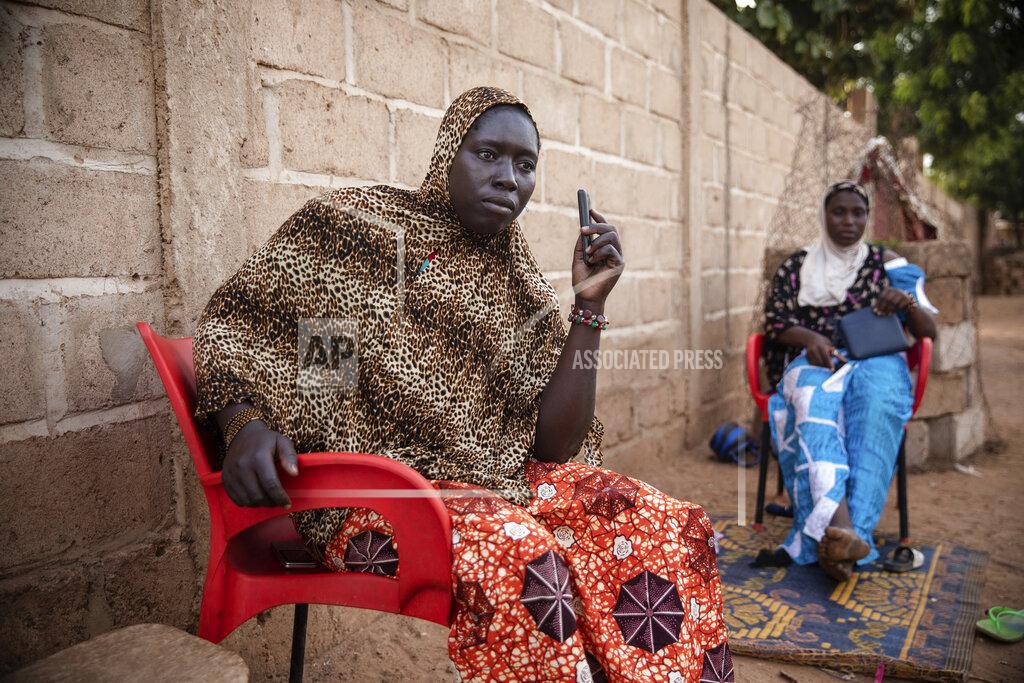 Sophie Garcia Women listen to Mariama Sawadogo on Zama Radio, in Kaya, Burkina Faso, October 25, 2021. Many guests and listeners in Burkina Faso call Sawadogo "aunty" as she gently guides them to the right answers and awards prizes such as soap and washing buckets. In the West African country of Burkina Faso, many feel the government has let them down during the pandemic. Tests, vaccines and messaging often miss many residents, despite a $200 million budget for virus-response efforts. In a region where women are responsible for family work and community relationships, they’ve stepped up to fill in gaps. (AP Photo/Sophie Garcia)