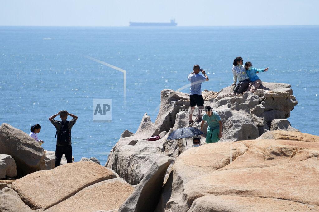 Ng Han Guan Tourists take photos on the waterfront at the 68-nautical-mile scenic spot, the closest point in mainland China to the island of Taiwan, in Pingtan in southeastern China's Fujian Province, Friday, Aug. 5, 2022. China conducted "precision missile strikes" Thursday in waters off Taiwan's coasts as part of military exercises that have raised tensions in the region to their highest level in decades following a visit by U.S. House Speaker Nancy Pelosi. (AP Photo/Ng Han Guan)