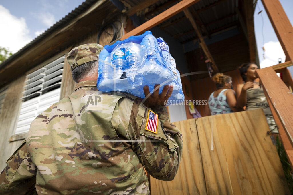 Alejandro Granadillo A National Guardsman delivers water to the residents of Punta Diamante in Ponce, Puerto Rico, Wednesday, September 21, 2022, after the area was hit by Hurricane Fiona. (AP Photo/Alejandro Granadillo)