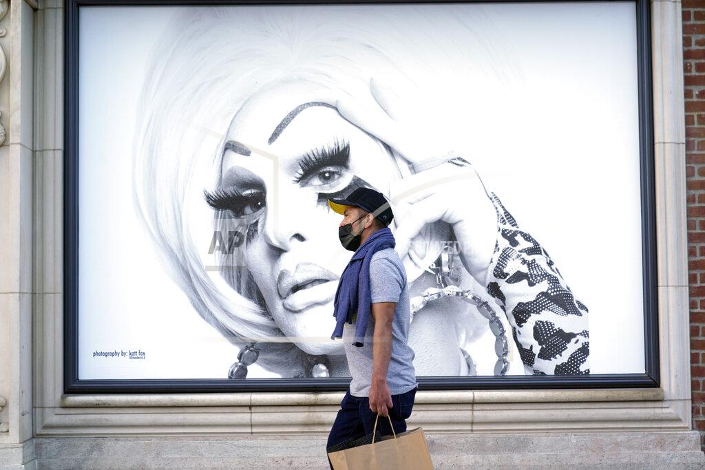 Marcio Jose Sanchez A shopper walks past a mural amid the COVID-19 pandemic on The Promenade Wednesday, June 9, 2021, in Santa Monica, Calif. (AP Photo/Marcio Jose Sanchez)