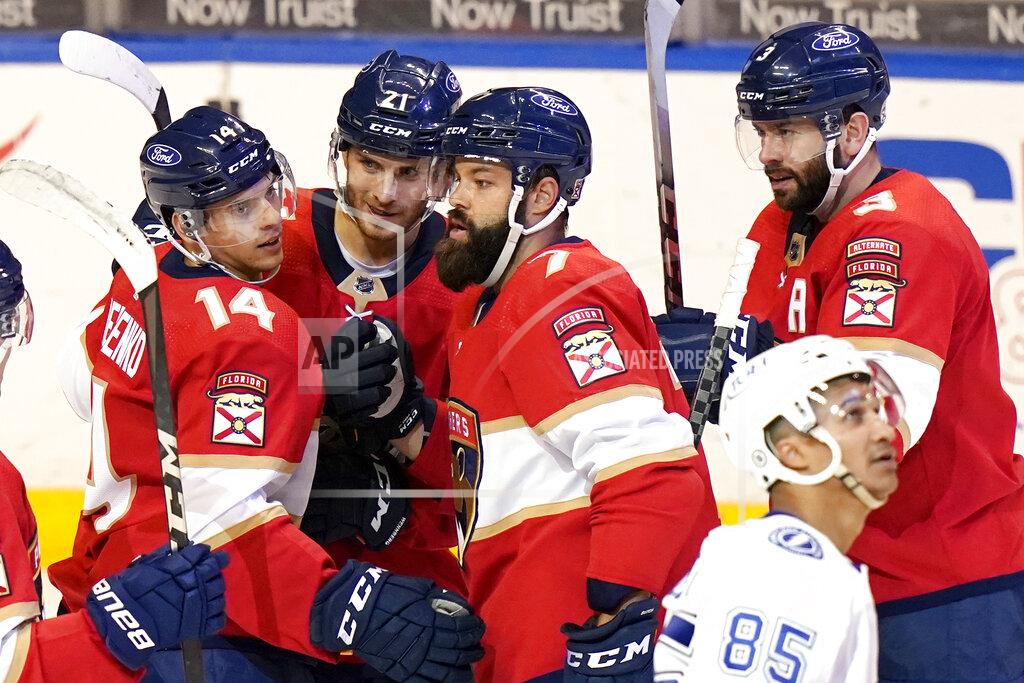 Lynne Sladky Florida Panthers center Alex Wennberg (21) is congratulated by left wing Grigori Denisenko (14), defenseman Radko Gudas (7) and defenseman Keith Yandle (3) after scoring a goal during the third period of an NHL hockey game against the Tampa Bay Lightning, Monday, May 10, 2021, in Sunrise, Fla. (AP Photo/Lynne Sladky)