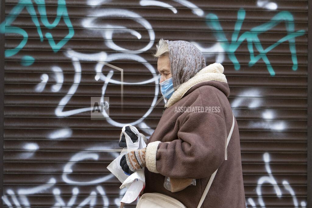 Evgeniy Maloletka A woman wearing a face mask to protect against coronavirus walks past a closed shop in Ivano-Frankivsk, Western Ukraine, Friday, Jan. 8, 2021. Ukraine imposed a wide-ranging lockdown beginning Friday, closing schools and entertainment venues and restaurant table service through Jan. 25. (AP Photo/Evgeniy Maloletka)