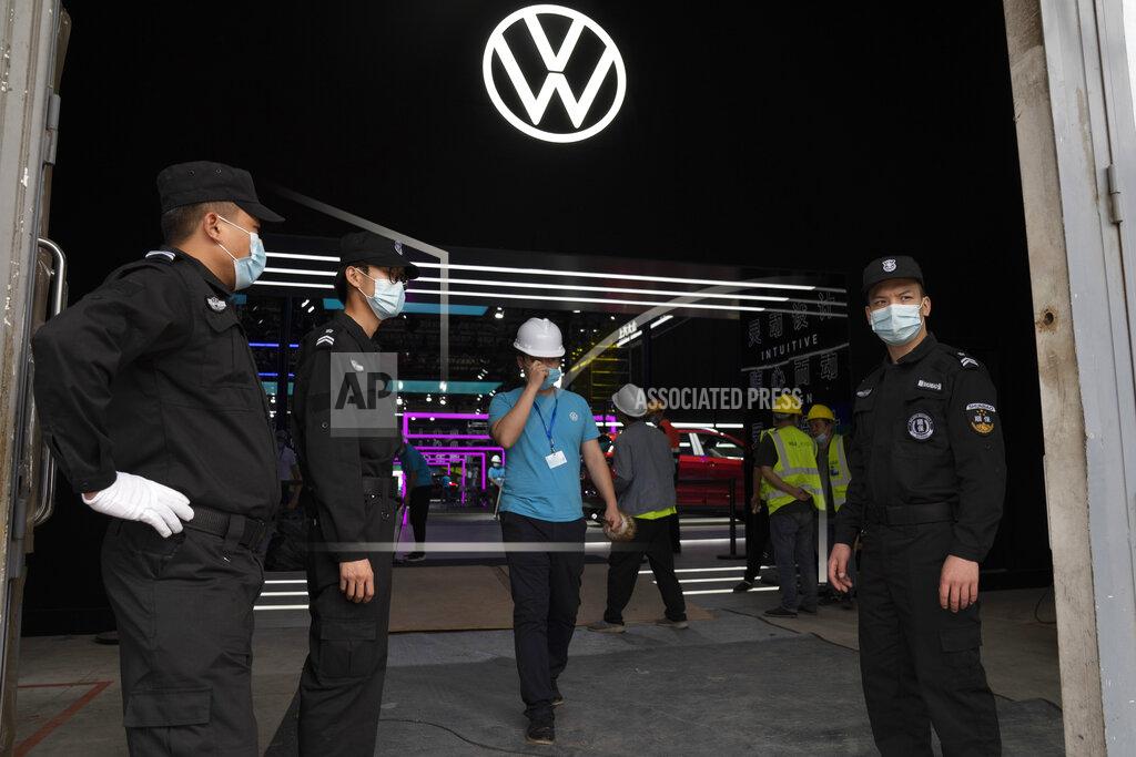 Ng Han Guan Security guards wearing masks stand at the entrance to the showroom being prepared ahead of the Auto China 2020 show to be held in Beijing on Thursday, Sept. 24, 2020. Auto executives are flying in early to wait out a coronavirus quarantine ahead of the Beijing auto show, the year's biggest sales event for a global industry that is struggling with tumbling sales and layoffs. (AP Photo/Ng Han Guan)