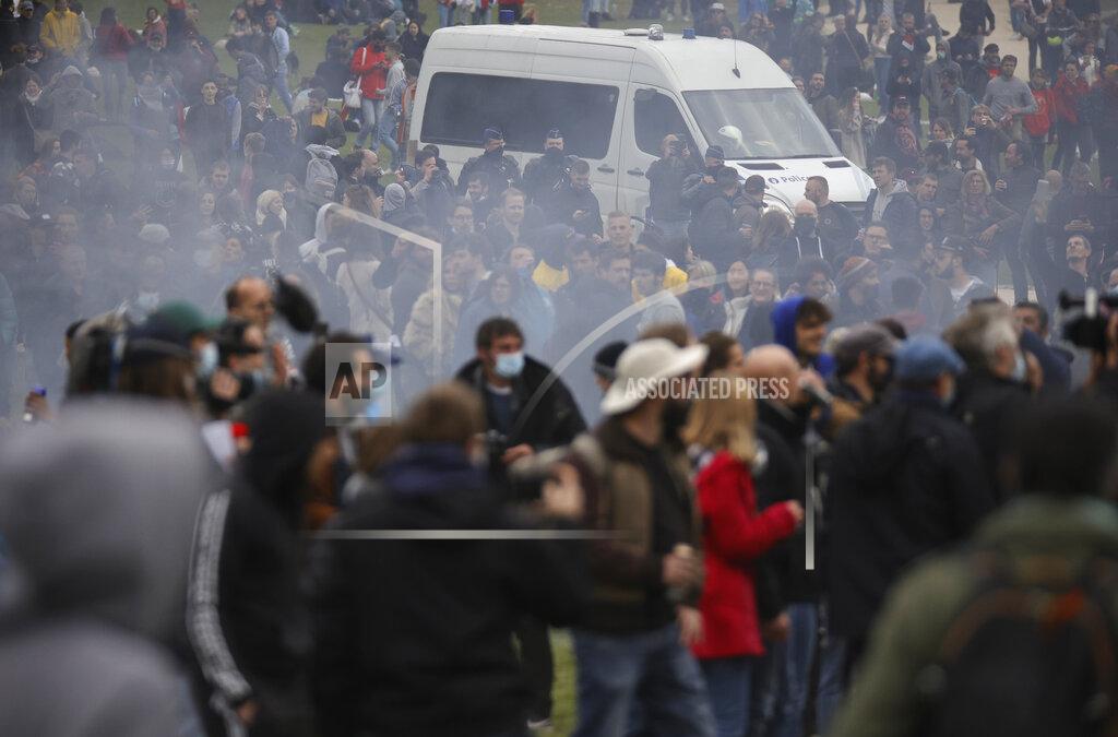 Olivier Matthys Police patrol in a van as people gather at the Bois de la Cambre park for a party called "La Boum 2" in Brussels, Saturday, May 1, 2021. Police put on extra patrols Saturday to monitor the gathering which is being held in defiance of Belgium's current COVID-19 regulations. (AP Photo/Olivier Matthys)