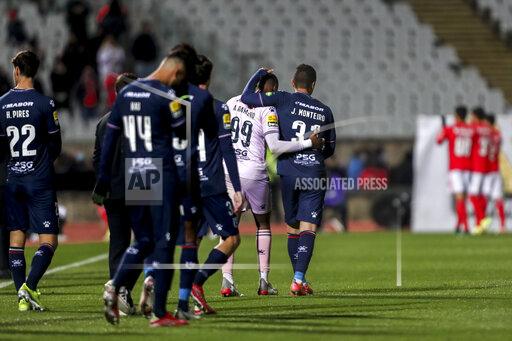 Belenenses' Joao Monteiro, center right, a goalkeeper who had to start as a field player, leaves the pitch with goalkeeper Alvaro Ramalho at the end of the Portuguese Primeira Liga soccer match between Belenenses SAD and SL Benfica, Saturday, Nov. 27, 2021. Belenenses SAD started the match with only nine players due to a coronavirus outbreak. Portuguese health authorities on Monday, Nov. 29, 2021, identified 13 cases of omicron, the new coronavirus variant spreading fast globally, among members of Belenenses SAD. (AP Photo/Pedro Rocha)