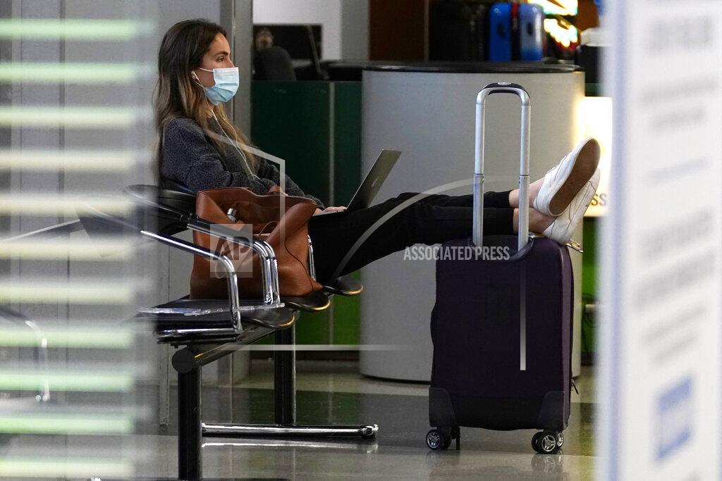 Nam Y. Huh FILE - A traveler wears a mask as she waits for her flight in Terminal 3 at O'Hare International Airport in Chicago, Sunday, Nov. 29, 2020. The coronavirus pandemic created winners and losers in the business world. Wall Street recovered after March, even though Main Street is still struggling. As few people traveled, the airline industry needed billions of dollars in aid from the government and is still threatening to lay off workers.(AP Photo/Nam Y. Huh)
