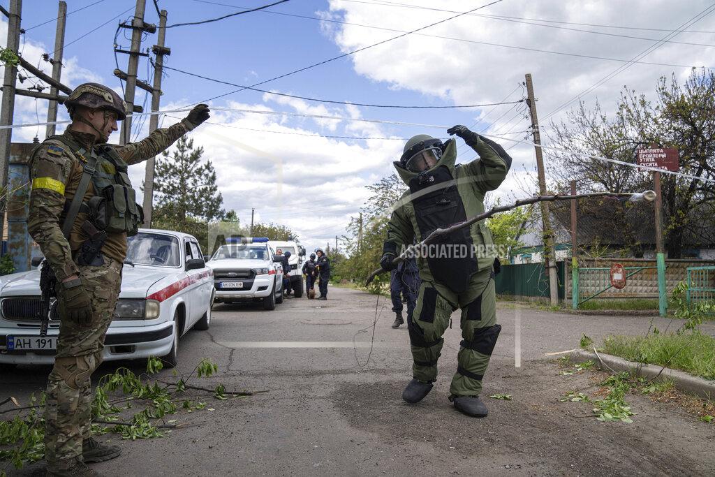Evgeniy Maloletka A de-miner wearing protective gear works in an area where unexploded devices were found after shelling of Russian forces in Maksymilyanivka, Ukraine, Tuesday, May 10, 2022. (AP Photo/Evgeniy Maloletka)