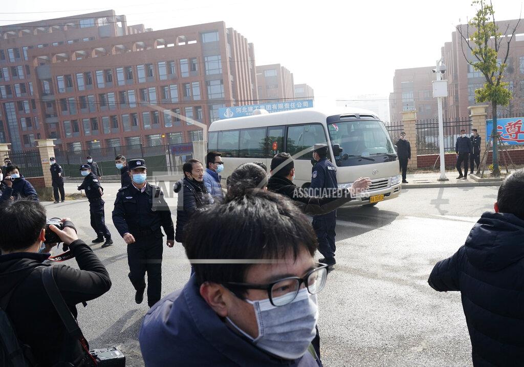 Journalists and security personnel gather near the entrance of the Wuhan Institute of Virology after a visit by the World Health Organization team in Wuhan in China's Hubei province on Wednesday, Feb. 3, 2021. (AP Photo/Ng Han Guan)