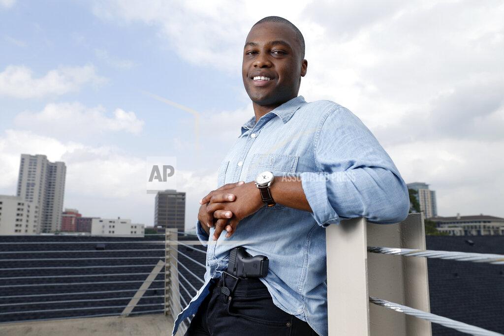 Michael Wyke Charles Blain, a new gun owner, poses with his holstered 9mm Glock 43 handgun, Monday, May 3, 2021, on the parking garage of his apartment complex in Houston. Blain also owns a shotgun and is currently completing his concealed carry license requirements to carry the handgun. Blain, who describes himself as a conservative, says "pandemic-related unemployment crime" and repeated calls over the past year to release hundreds of jail inmates because of soaring COVID-19 infections pushed him to buy. (AP Photo/Michael Wyke)
