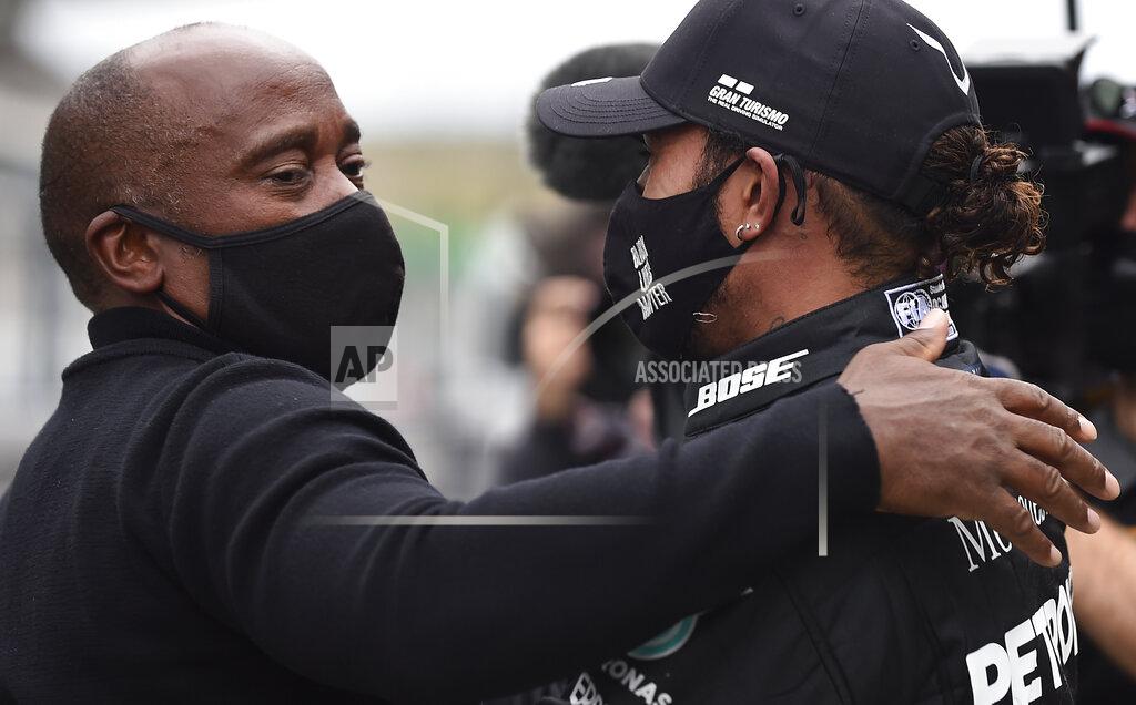 Jorge Guerrero Mercedes driver Lewis Hamilton of Britain is congratulated by his father Anthony Hamilton after his record breaking win during the Formula One Portuguese Grand Prix at the Algarve International Circuit in Portimao, Portugal, Sunday, Oct. 25, 2020. (Jorge Guerrero, Pool via AP)