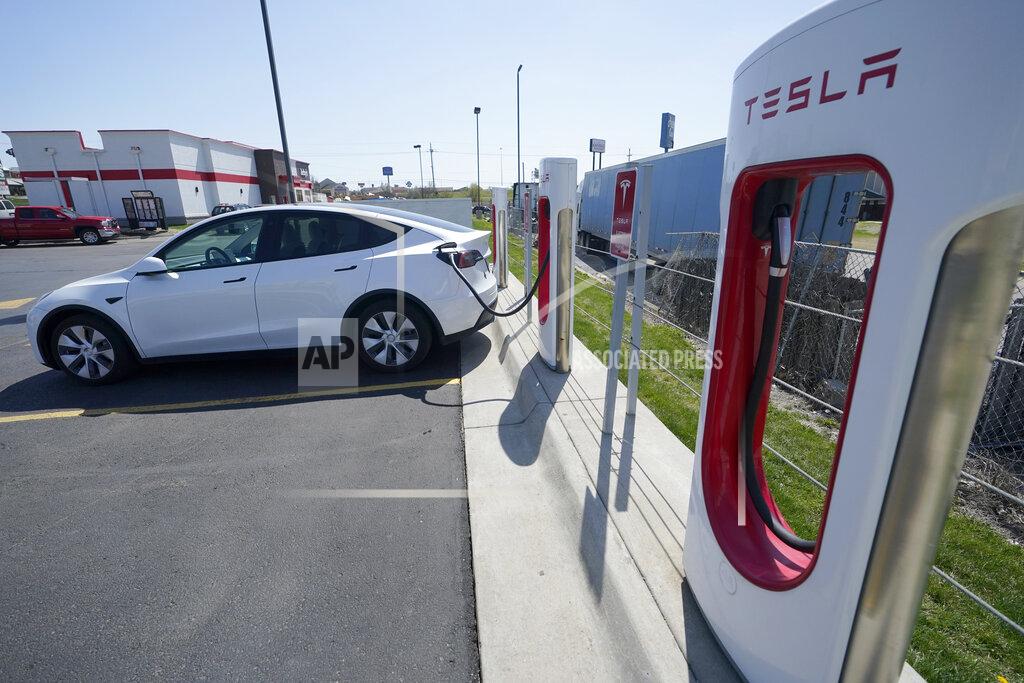 Orlin Wagner A Tesla charges at a station in Topeka, Kan., Monday, April 5, 2021. The president and the auto industry maintain the nation is on the cusp of a gigantic shift to electric vehicles and away from liquid-fueled cars, but biofuels producers and some of their supporters in Congress aren’t buying it. They argue the U.S. should increase sales of ethanol and biodiesel, not abandon them. (AP Photo/Orlin Wagner)