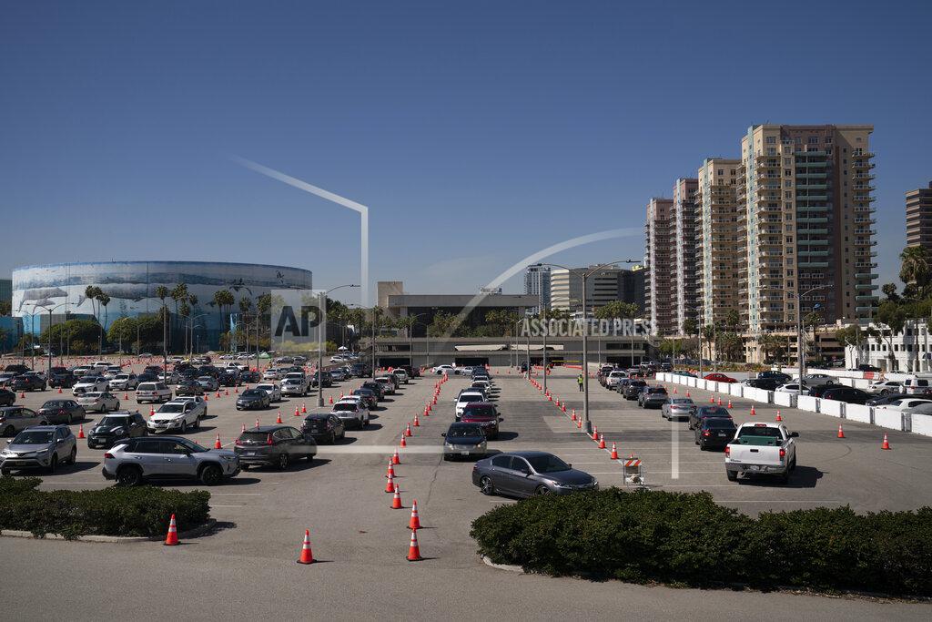 Motorists line up at a COVID-19 vaccination site in Long Beach, Calif., Friday, March 5, 2021. More than 27 million Americans fully vaccinated against the coronavirus will have to keep waiting for guidance from U.S. health officials for what they should and shouldn't do. The Biden administration said Friday it's focused on getting the guidance right and accommodating emerging science. (AP Photo/Jae C. Hong)