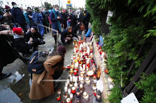 FILE - In this Monday, Sept. 20, 2021 file photo, Warsaw residents place candles before the national Border Guards Headquarters in Warsaw, Poland, as a sign of mourning for four migrants found dead over the weekend along the border between Poland and Belarus. Two United Nations agencies requested access Tuesday Sept. 21, 2021, to asylum-seekers stranded at Belarus's border with Poland and Lithuania, after four migrants were found dead in the area. (AP Photo/Czarek Sokolowski, File)