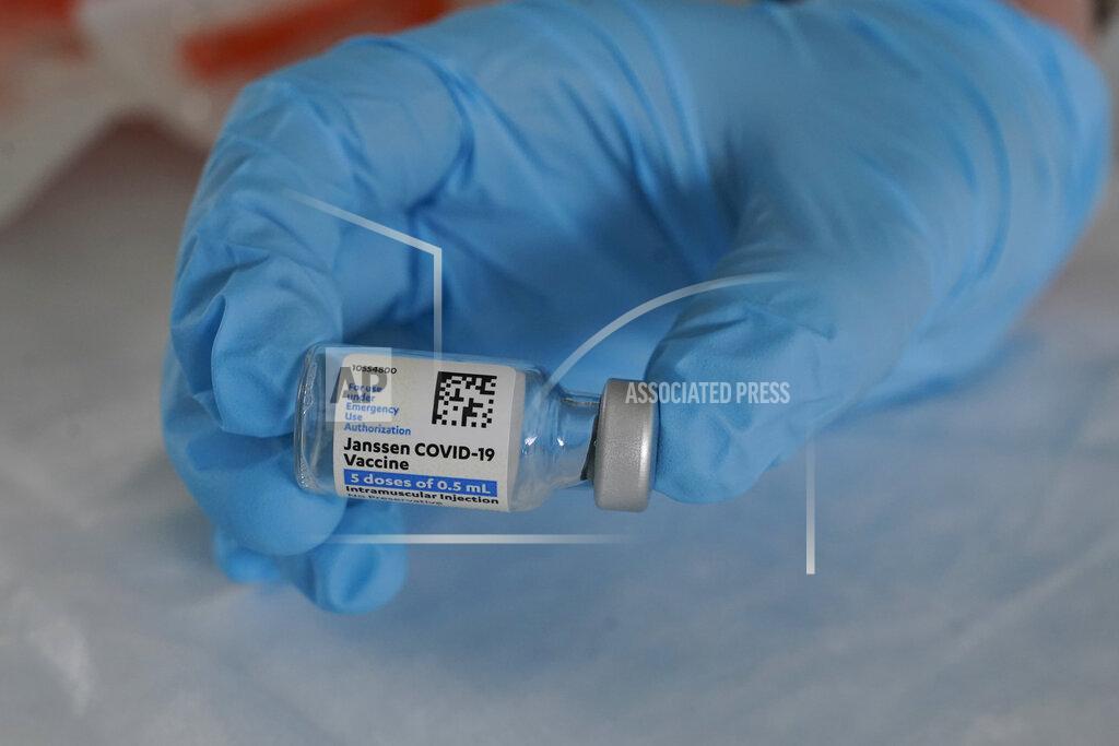 FILE - In this March 3, 2021, file photo, U.S. Army medic Kristen Rogers, of Waxhaw, N.C., holds a vial of the Johnson & Johnson COVID-19 vaccine in North Miami, Fla. With the U.S. pause of the vaccine, authorities are weighing whether to resume the shots the way European regulators decided to -- with warnings of a “very rare” risk. New guidance is expected late Friday, April 23, after a government advisory panel deliberates a link between the shot and a handful of vaccine recipients who developed highly unusual blood clots. (AP Photo/Marta Lavandier, File)