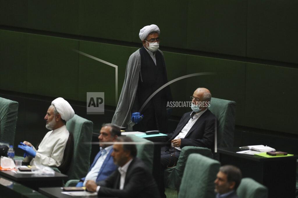Vahid Salemi A cleric lawmaker wearing a protective face mask and gloves to help prevent the spread of the coronavirus walks through the parliament during the inauguration of Iran's new parliament, in Tehran, Iran, Wednesday, May, 27, 2020. Iran has convened its newly elected parliament, dominated by conservative lawmakers and under strict social distancing regulations, as the country struggles to curb the spread of coronavirus that has hit the nation hard. Iran is grappling with one of the deadliest outbreaks in the Middle East. (AP Photo/Vahid Salemi)