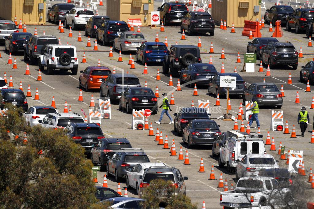FILE - In this July 14, 2020, file photo, people wait in line for coronavirus testing at Dodger Stadium in Los Angeles. After months of struggling to ramp up coronavirus testing, the U.S. is now capable of testing some 3 million people daily thanks to a growing supply of rapid tests. But the testing boom comes with a new challenge: keeping track of the results. (AP Photo/Mark J. Terrill, File)
