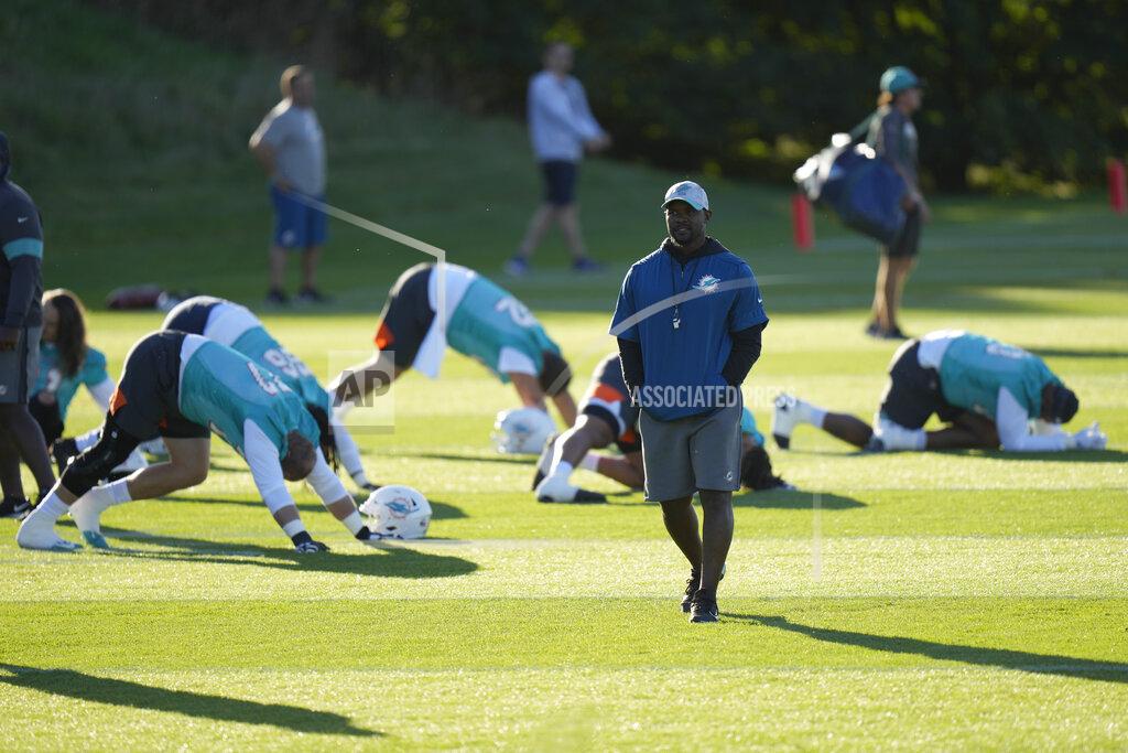 Alastair Grant Brian Flores Head Coach of the Miami Dolphins walks amongst his players during a practice and media availability by the Miami Dolphins In Ware, England, Friday, Oct. 15, 2021. The Dolphins play the Jaguars in a regular season NFL game on Sunday at Tottenham Hotspurs White Hart Lane stadium in London. (AP Photo/Alastair Grant)