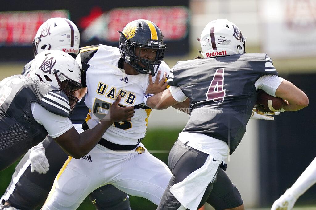 Rogelio V. Solis Alabama A&M quarterback Aqeel Glass (4) evades a sack attempt by Arkansas-Pine Bluff defensive lineman Jamari Watson (58) during the first half of the Southwestern Athletic Conference championship NCAA college football game Saturday, May 1, 2021, in Jackson, Miss. Alabama A&M won 40-33. (AP Photo/Rogelio V. Solis)