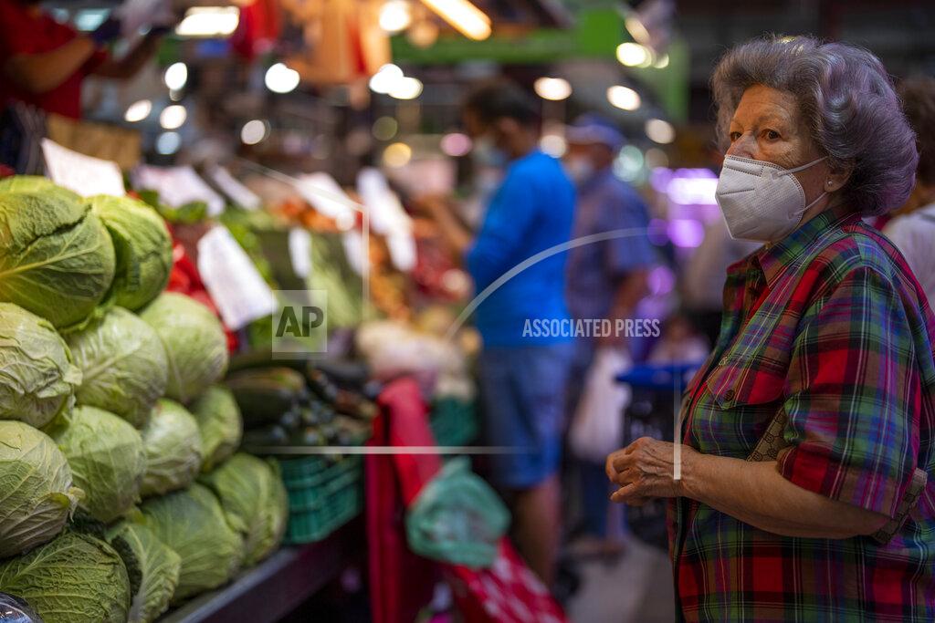 Manu Fernandez A customer wearing a face mask waits to buy vegetables at the Maravillas market in Madrid, Thursday, May 12, 2022. Russia's war in Ukraine has accelerated inflation across Europe, with prices for energy, materials and food surging at rates not seen for decades. Inflation is expected to hit nearly 7% this year in the 27-nation EU and is contributing to slowing growth forecasts. (AP Photo/Manu Fernandez)