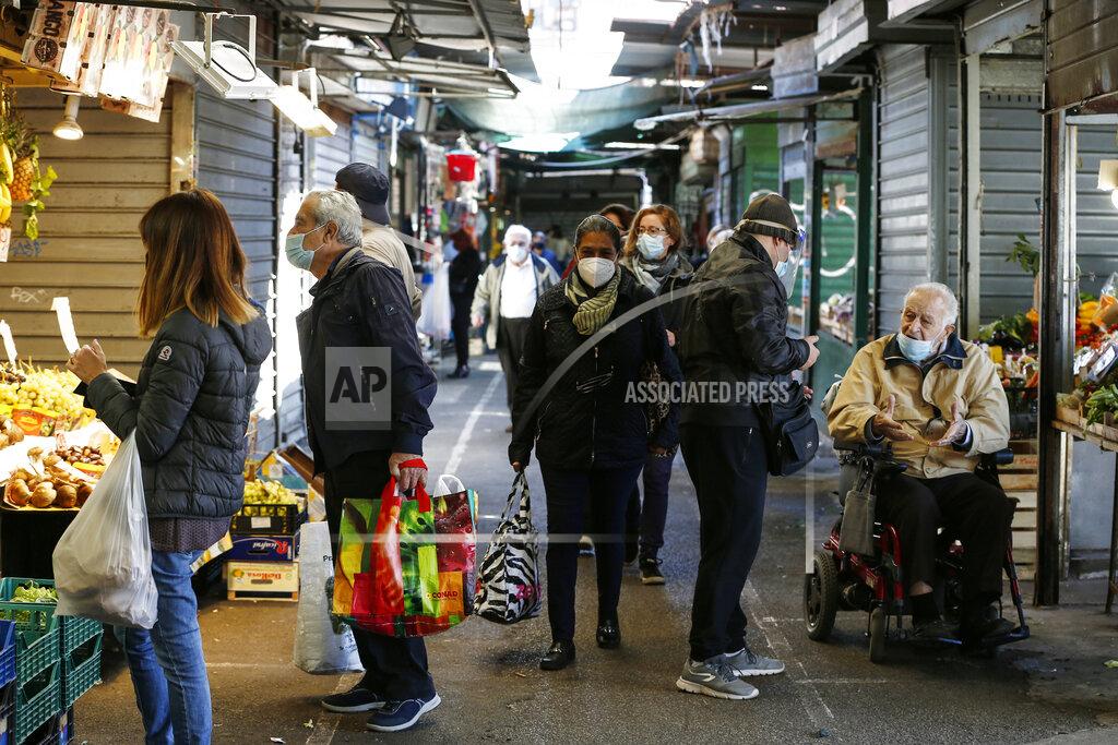 Cecilia Fabiano People wearing masks hold bags while shopping at an open-air market in Rome, Thursday, Oct. 22, 2020. Authorities in regions including Italy's three largest cities have imposed curfews in a bid to slow the spread of COVID-19 where it first struck hard in Europe, most of whose countries are now imposing, or mulling, new restrictions to cope with rapidly rising caseloads. (Cecilia Fabiano/LaPresse via AP)