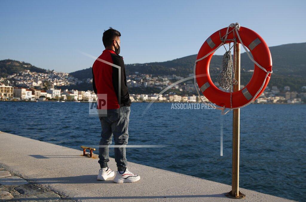 Thanassis Stavrakis An Afghan father stands at the port of Vathy on the eastern Aegean island of Samos, Greece, Monday, Feb. 22, 2021. On a hill above a small island village, the sparkling blue of the Aegean just visible through the pine trees, lies a boy’s grave. His first ever boat ride was to be his last - the sea claimed him before his sixth birthday. His 25-year-old father, like so many before him, had hoped for a better life in Europe, far from the violence of his native Afghanistan. But his dreams were dashed on the rocks of Samos, a picturesque Greek island almost touching the Turkish coast. Still devastated from losing his only child, the father has now found himself charged with a felony count of child endangerment. (AP Photo/Thanassis Stavrakis)