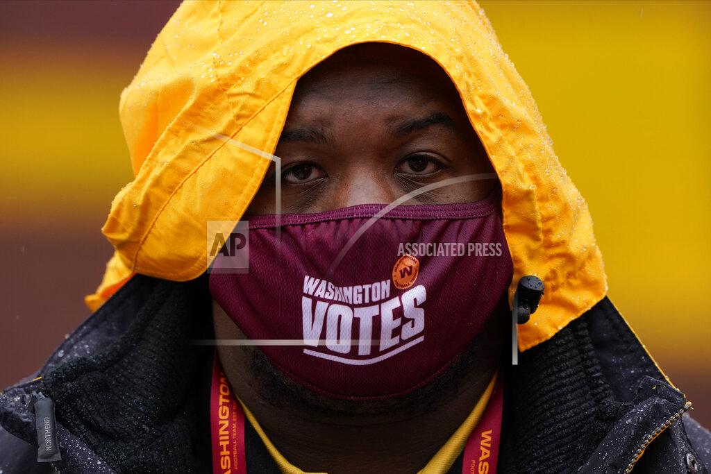 Susan Walsh Stadium employee Marlowel Matthews wears his face mask before the start of an NFL football game between the Dallas Cowboys and Washington Football Team, Sunday, Oct. 25, 2020, in Landover, Md. (AP Photo/Susan Walsh)