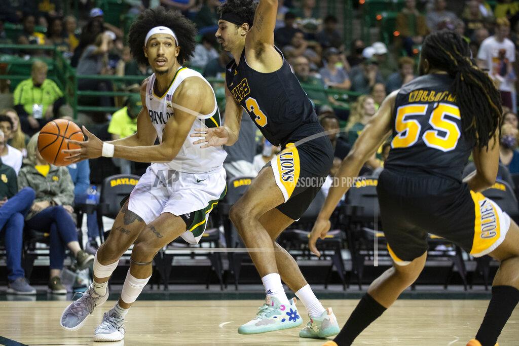 Emil Lippe Baylor guard Kendall Brown (2) drives past Arkansas-Pine Bluff forward Trey Sampson (23) while looking for an open teammate in the first half of an NCAA college basketball game in Waco, Texas, Saturday, Dec. 4, 2021. (AP Photo/Emil Lippe)