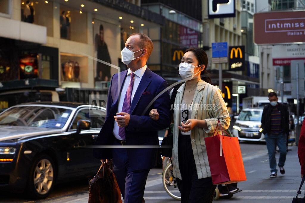 Kin Cheung People wearing face masks to protect against the spred of the coronavirus, walk along a street in Hong Kong, Monday, Nov. 30, 2020. (AP Photo/Kin Cheung)