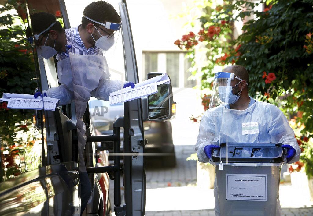 Boris Grdanoski Members of a special election team with a ballot box and voting material check a list of voters who have tested positive for COVID-19 or are in self-isolation, in Skopje, North Macedonia, Monday, July 13, 2020. North Macedonia holds its first parliamentary election under its new country name this week, with voters heading to the polls during an alarming spike of coronavirus cases in the small Balkan nation. Opinion polls in the run-up to Wednesday’s vote indicate a close race between coalitions led by the Social Democrats and the center-right opposition VMRO-DPMNE party. (AP Photo/Boris Grdanoski)